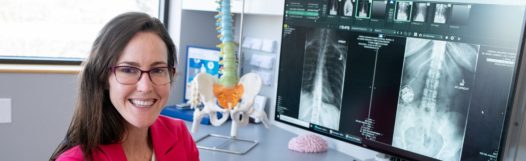Dr. Angela Bohnen, Denver neurosurgeon, showing images of spinal cord stimulator implanted in spine.