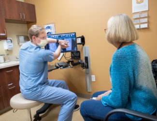 Denver neurosurgeon Josh Beckman explains scoliosis to a patient.