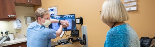 Denver neurosurgeon Josh Beckman explains scoliosis to a patient.