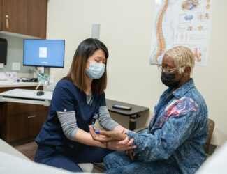 Image of Spine doctor helping patient with some at-home remedies for back pain.