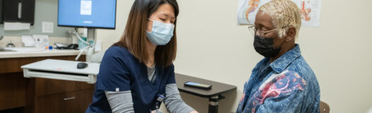 Image of Spine doctor helping patient with some at-home remedies for back pain.