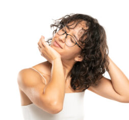 image of a young woman cracking her neck on a white studio background
