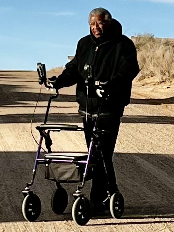 Dr. Garret walks on trail with assistance from his walker.