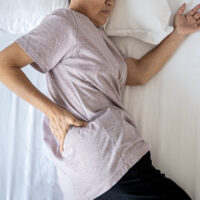 elderly woman experiencing pain while sleeping
