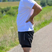 man experiencing back pain outdoors