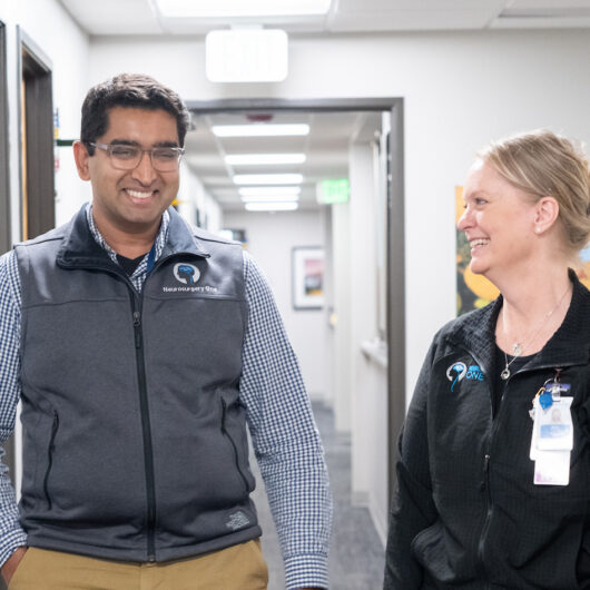 Julie, DBs Nurse NAvigator, and Dr. Gummadavelli neurosurgeon talk at the clinic