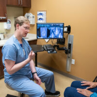 Dr. Beckman, Denver neurosurgeon, talks with a patient.